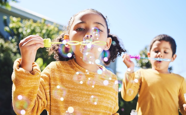 Photo boy girl and playing with bubbles outdoor in garden backyard or park with happiness family or siblings children soap bubble game and playful in childhood youth and summer sunshine on holiday