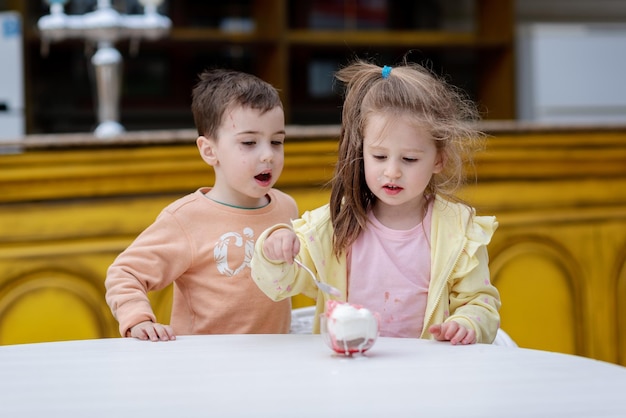 A boy and girl playing with a ice cream cone