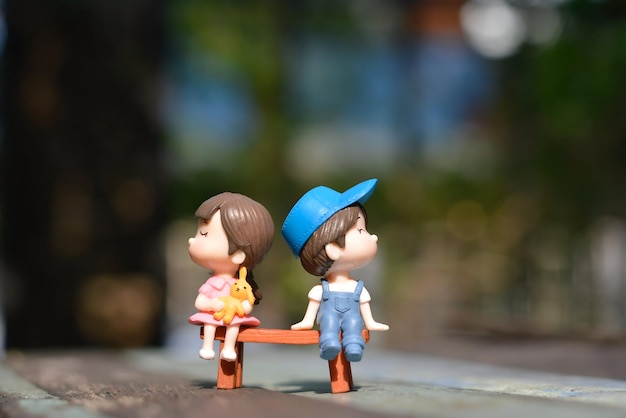 Photo boy and girl sitting on bench toy