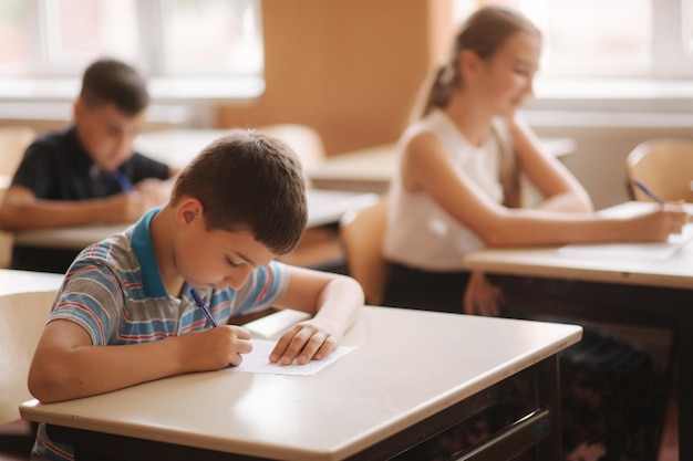 Boy and girl sitting at desk and writing a text