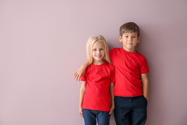 Photo boy and girl in t-shirts on color surface