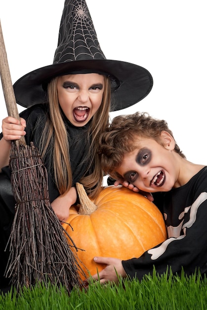 Foto ragazzo e ragazza che indossano il costume di halloween con zucca su sfondo bianco