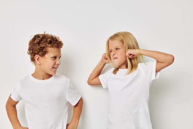 Boy and girl in white Tshirts are standing next to isolated background