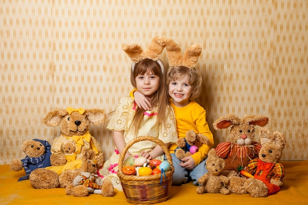 Мальчик и девочка с заячьими ушками и игрушками