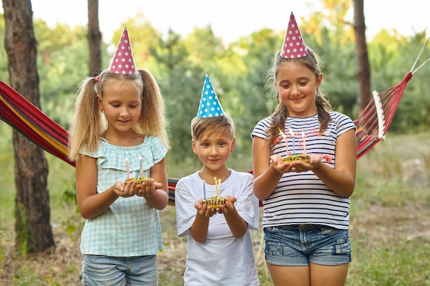 庭で屋外の誕生日を祝う男の子と女の子