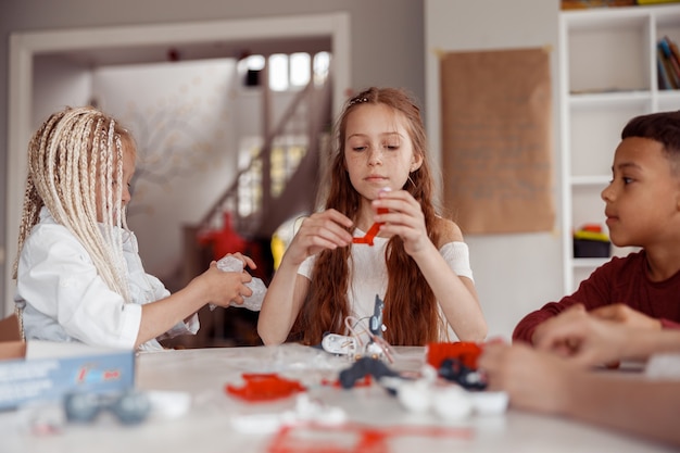 Boy and girls constructing model with constructor details in school