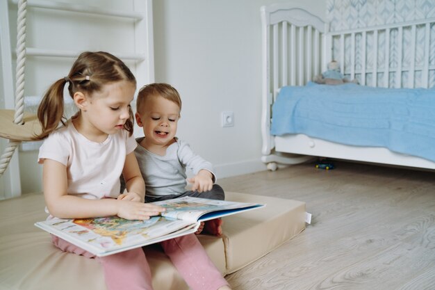 boy and girls reading a book in child room