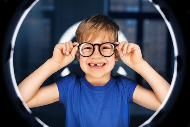 boy in glasses over illumination in dark room
