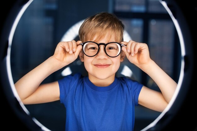 boy in glasses over illumination in dark room