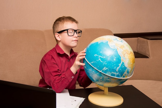 A boy in glasses sitting at a black table