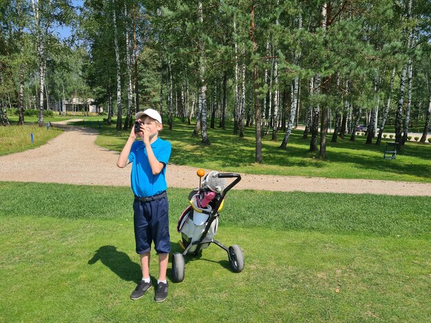 Boy golfer watching into rangefinder at his hit concept