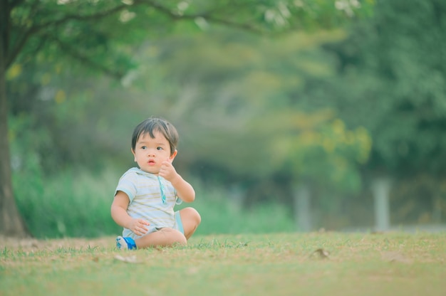 夏の日の緑の芝生の上の少年