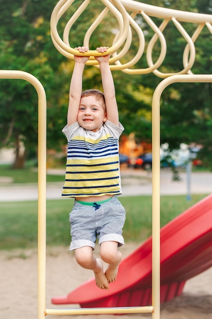 Boy hanging over equipment in playground