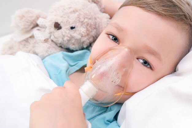 少年は、肺の治療のための吸入、手順を持っています。