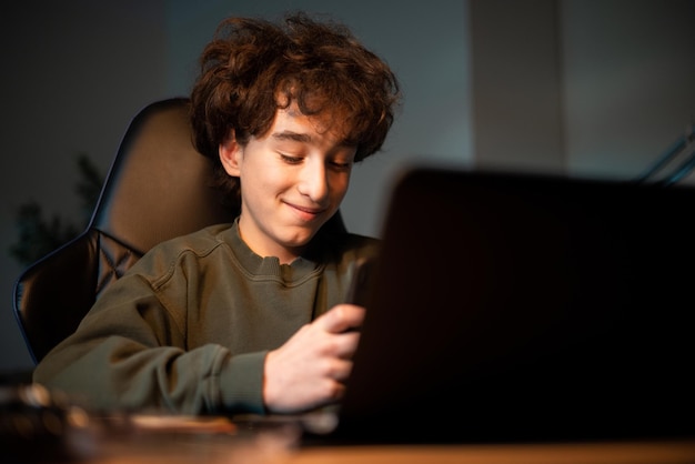 Boy has remote classes doesn't listen to teacher uses phone browses social media surfs the Internet