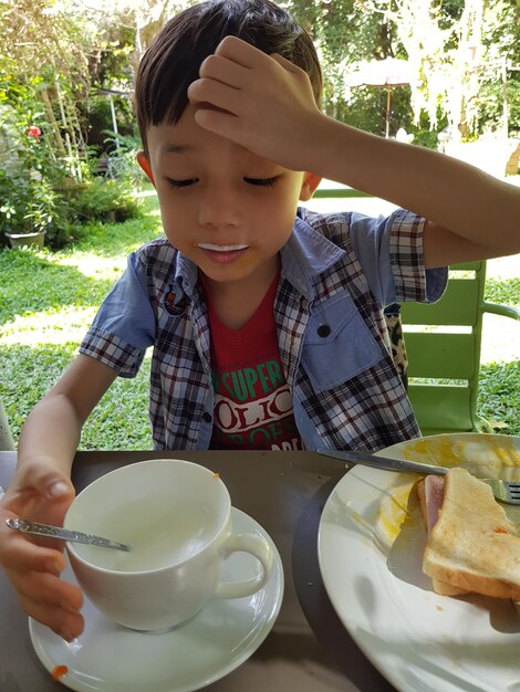 Foto ragazzo che fa colazione in cortile