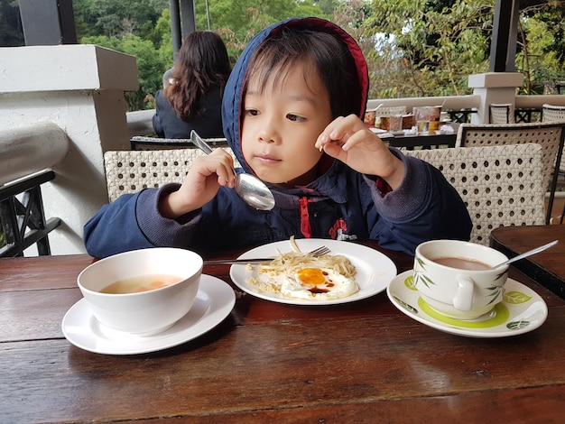 Boy having food at table in restaurant