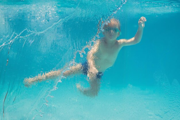 写真 夏休みにプールで水中遊びを楽しんでいる少年