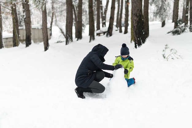 雪の中でお母さんと楽しむ男の子