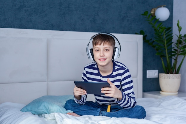 Boy in headphone looking and playing on phone