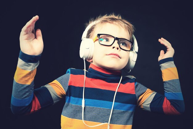 The boy in the headphones On a black background in the studio Closeup