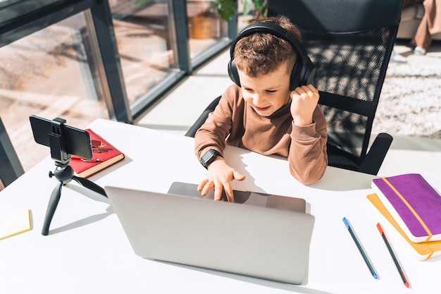 Boy in headphones sitting at laptop