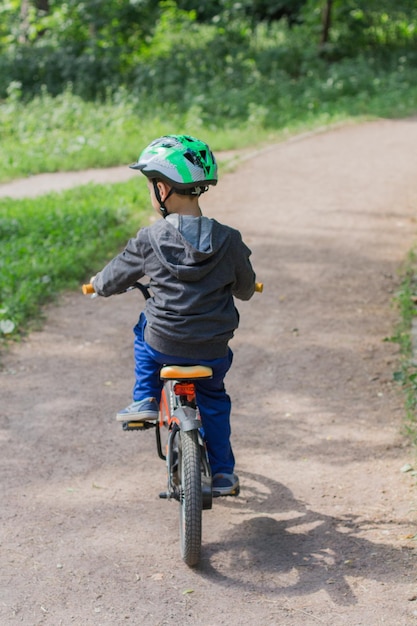 公園で自転車に乗ってヘルメットをかぶった少年