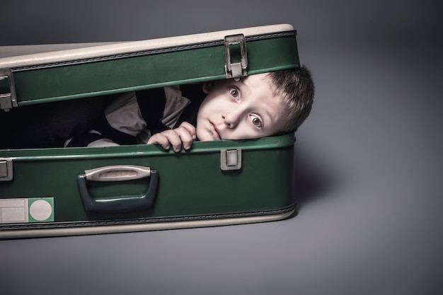 Boy hides in an old suitcase