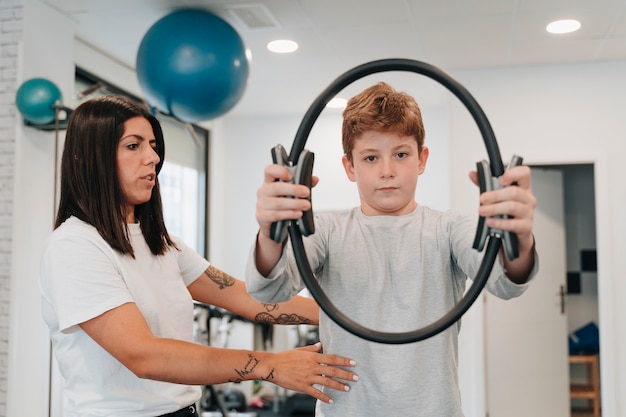 Boy in his 10s doing rehabilitation exercises with a physio