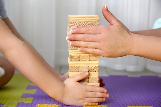 Boy and his mother put the jenga tower together and clean their hands carefully