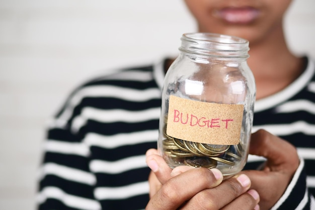 Boy holding a coin jar with budget text