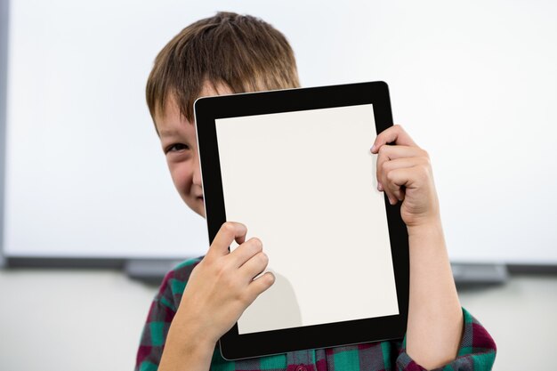 Boy holding digital tablet in classroom