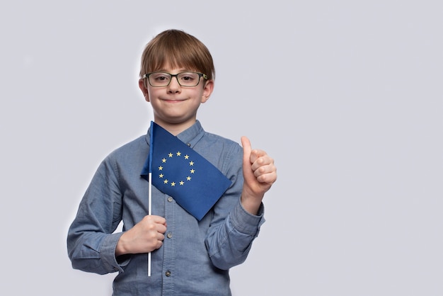 Мальчик держит флаг ЕС и показывает хорошо сделанный жест
