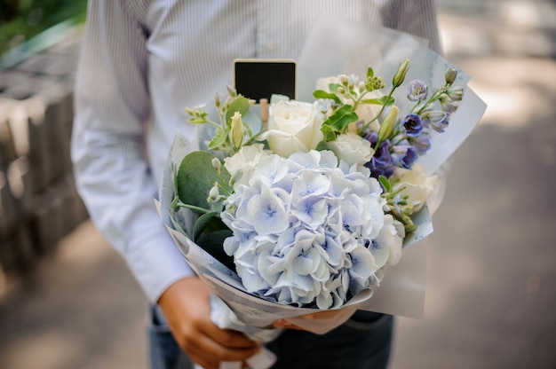 Boy holding a festive bright bouquet of flowers in blue tones