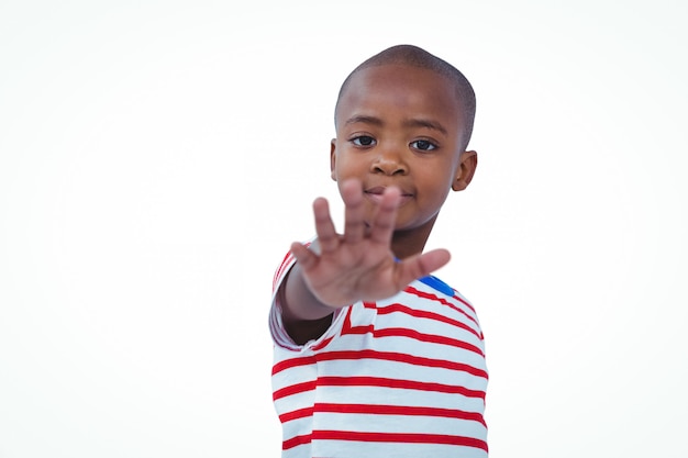 Photo boy holding his hand on the camera on white screen