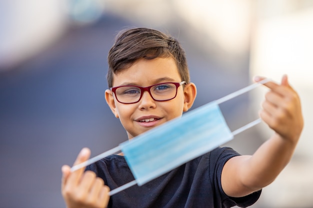 Boy holding a medical mask, closeup. Stop coronavirus