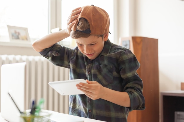 Photo boy holding mobile phone at home