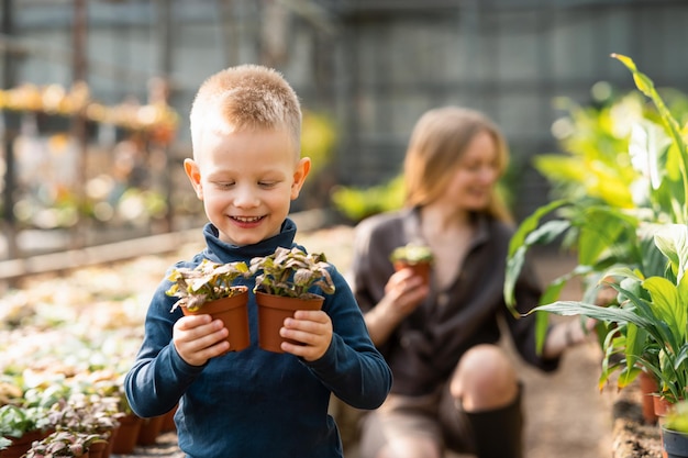 手に植物と鍋を保持している少年