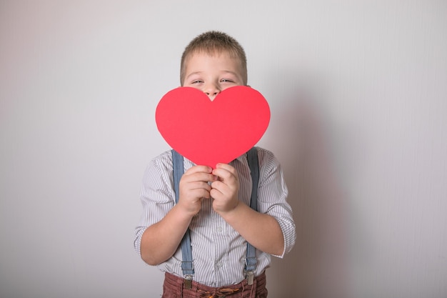 мальчик держит красное сердце