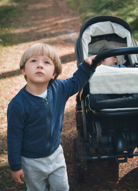 写真 公園でベビーボーイとベビーカーを抱いている男の子