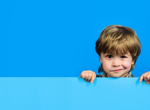 Photo boy holds blank sign child boy holds empty billboard little boy holds blank advertising banner funny