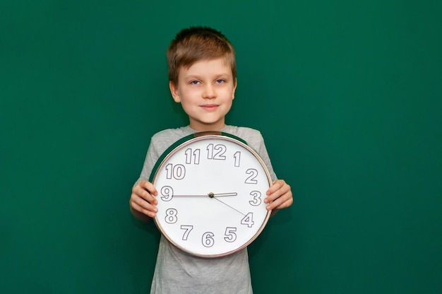 Boy holds a large clock in her hands
