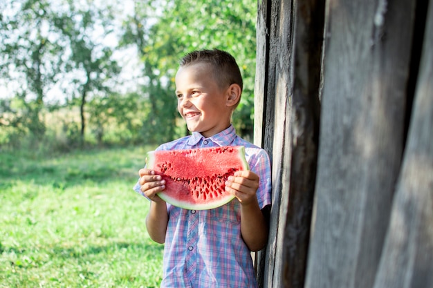 Boy holds a large piece of watermelon