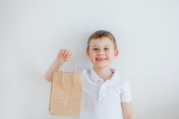 The boy holds a paper bag in his hands. Eco-packaging. Eco.