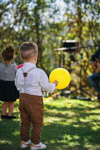 男の子がバンドの前で黄色い風船を持っています。