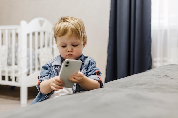 写真 携帯電話を使用して寝室の少年