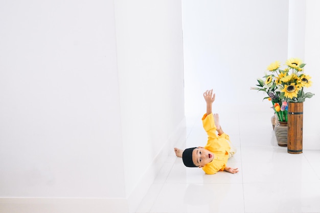 写真 伝統的な服を着た少年が床に横たわっている