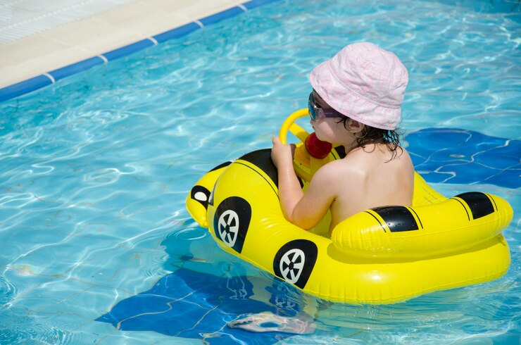 Photo boy on an inflatable yellow car in the pool