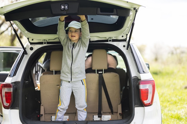 Photo boy inside car open trunk at picnic