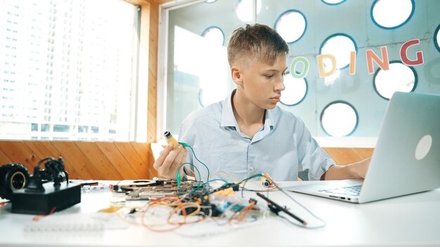 Photo boy inspect or learning to use electronic tool to fix car model edification